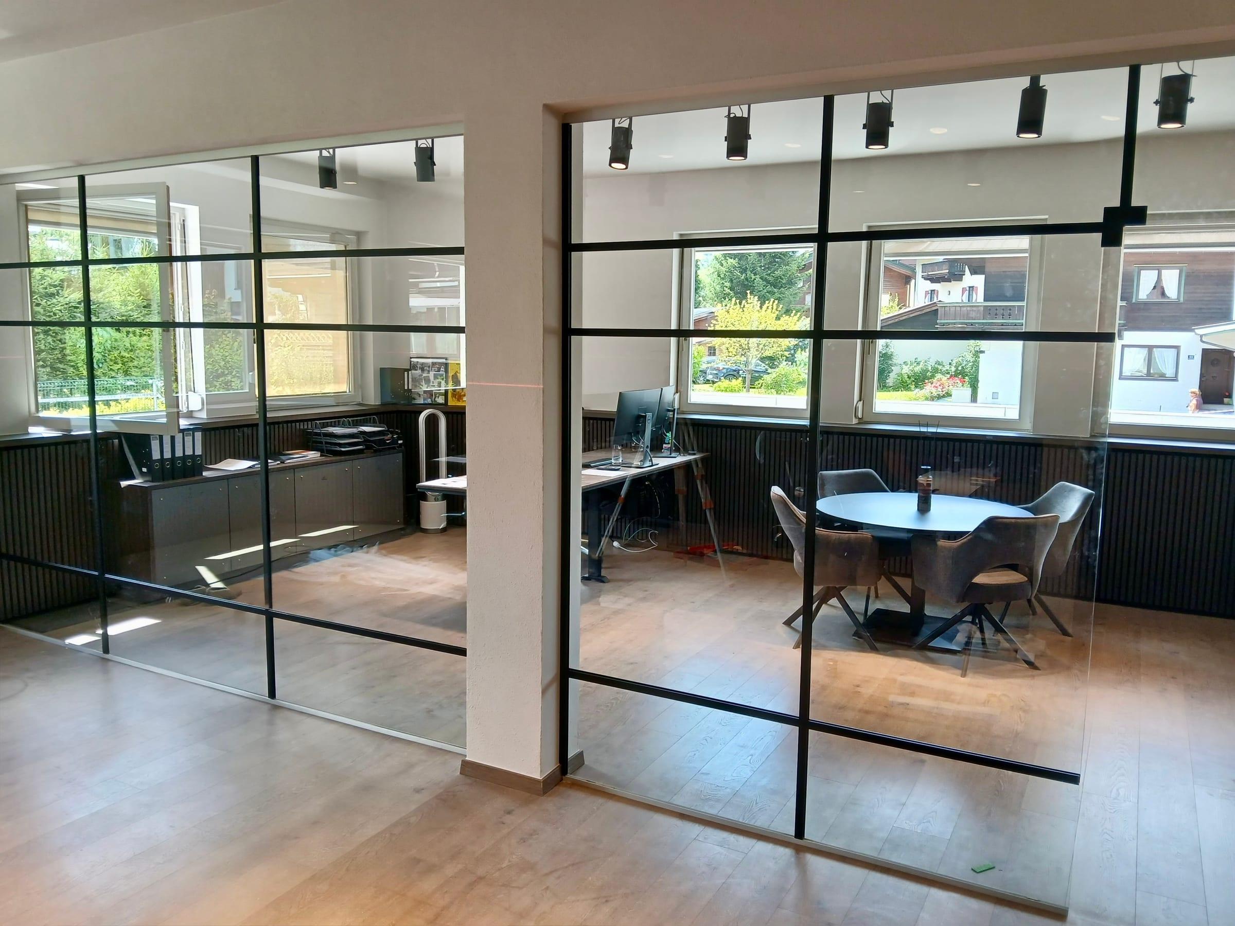 Büro hinter Glastrennwänden mit schwarzen Sprossen