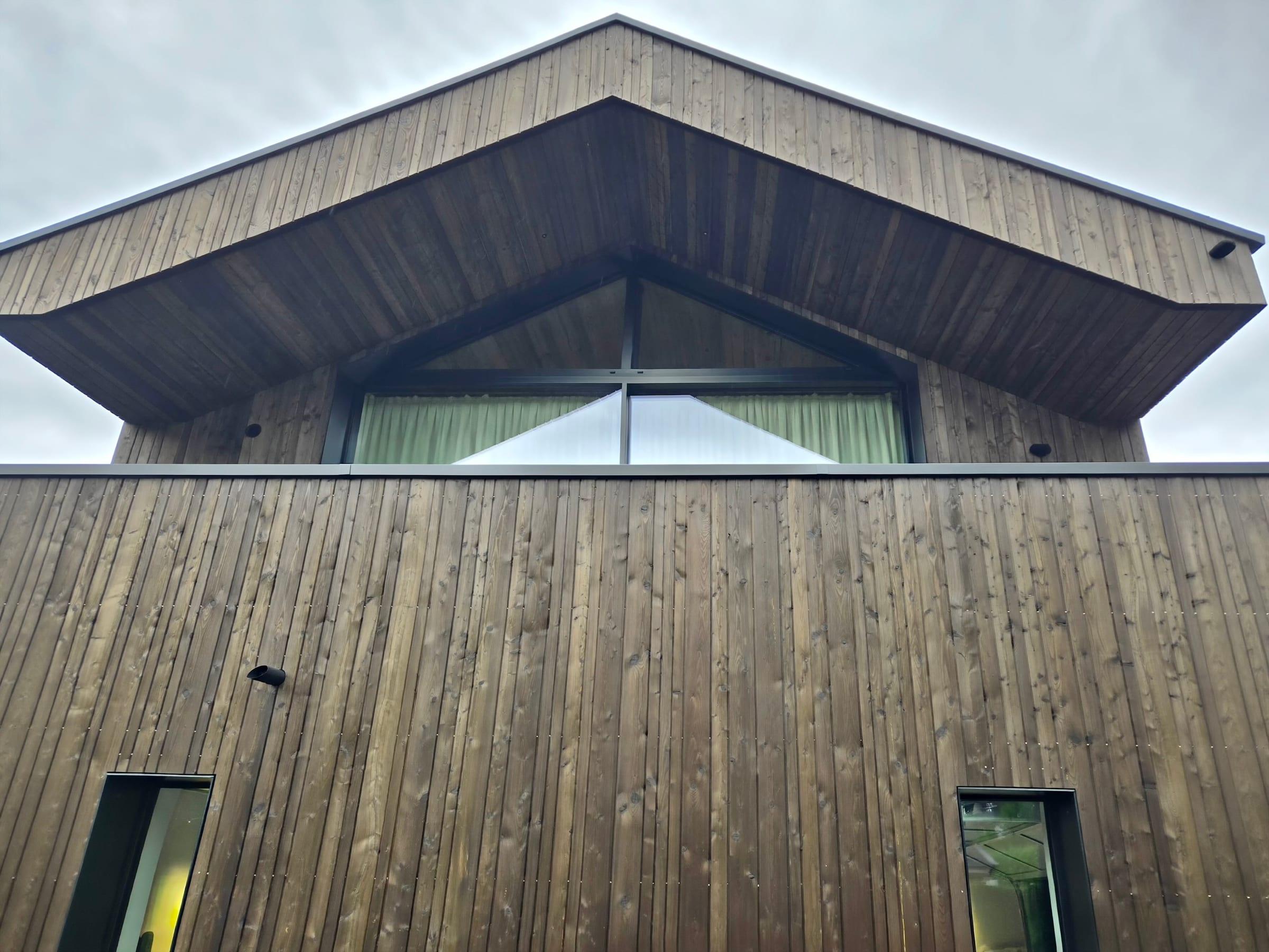 Giebel mit Holzfassade und Dachkante aus Metall
